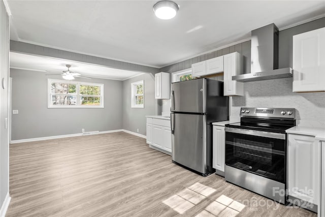 kitchen featuring white cabinetry, wall chimney exhaust hood, appliances with stainless steel finishes, and light wood-type flooring