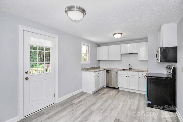 1613 Ohenry Ln, Fort Mill, SC 29708 - kitchen with stainless steel appliances, light wood finished floors, white cabinets, a textured ceiling, and decorative backsplash