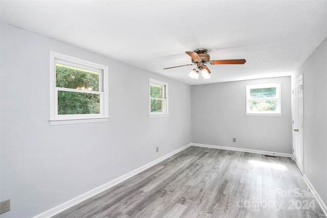 1613 Ohenry Ln, Fort Mill, SC 29708 - empty room featuring plenty of natural light, wood finished floors, ceiling fan, and a textured ceiling