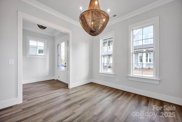 unfurnished dining area featuring crown molding, a notable chandelier, and light hardwood / wood-style flooring