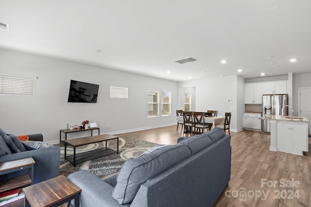 living room featuring light hardwood / wood-style flooring and sink