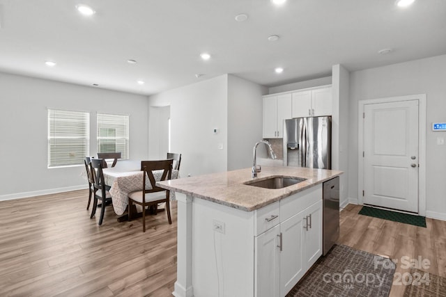 kitchen featuring a kitchen island with sink, stainless steel appliances, white cabinetry, and sink