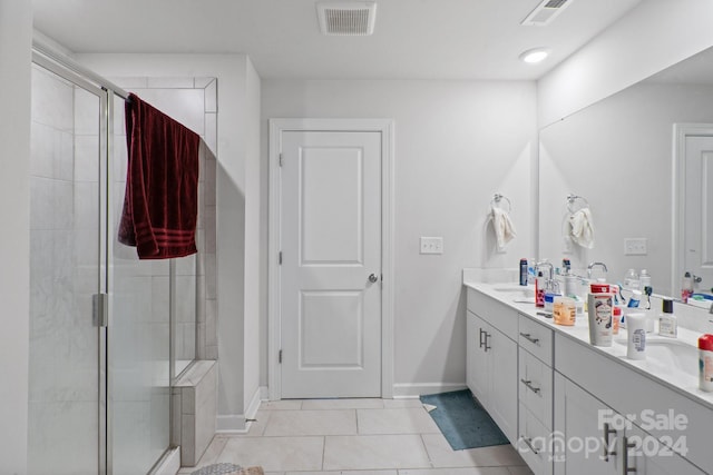 bathroom featuring tile patterned flooring, an enclosed shower, and vanity