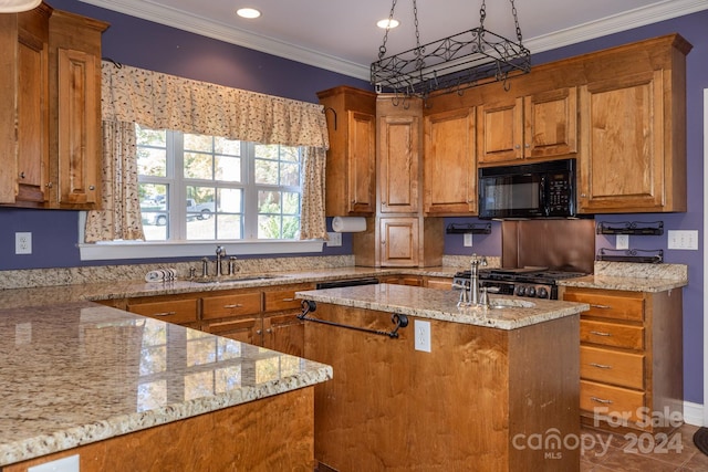 kitchen featuring a center island with sink, light stone counters, stainless steel range, crown molding, and sink