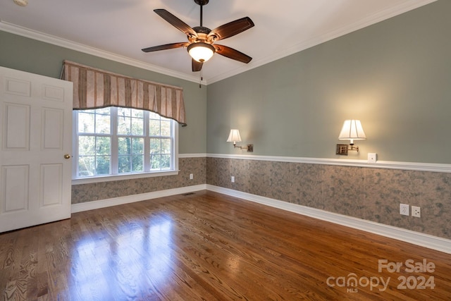 empty room with ornamental molding, hardwood / wood-style floors, and ceiling fan