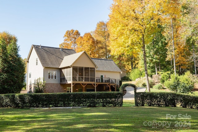 back of house with a yard and a sunroom