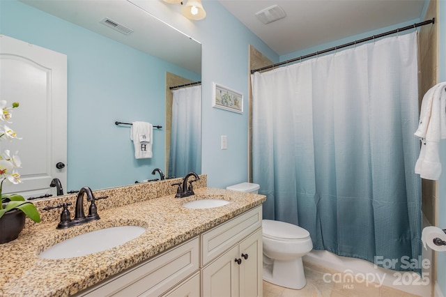 bathroom with vanity, tile patterned floors, and toilet