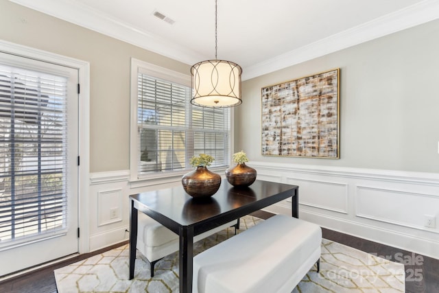 dining area featuring ornamental molding and dark wood-type flooring