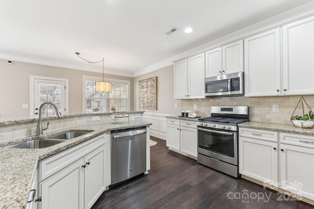 kitchen featuring pendant lighting, sink, white cabinets, stainless steel appliances, and light stone countertops