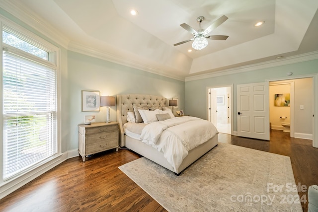 bedroom featuring crown molding, dark hardwood / wood-style floors, a tray ceiling, and ceiling fan