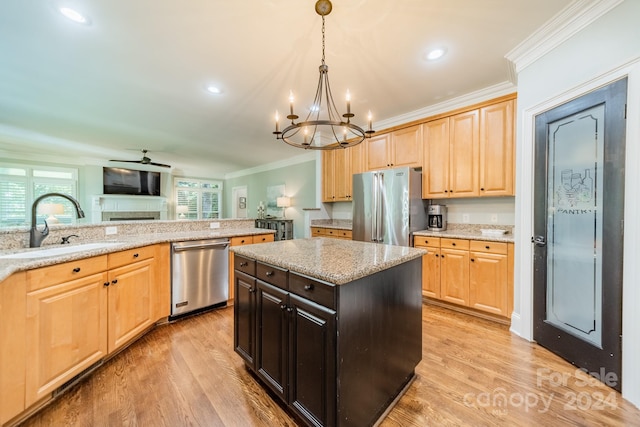 kitchen with light hardwood / wood-style flooring, ornamental molding, stainless steel appliances, and light stone counters