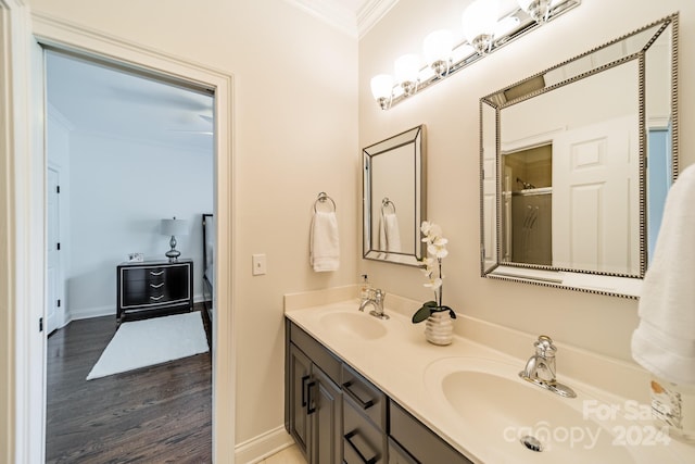 bathroom with vanity, ornamental molding, wood-type flooring, and a shower with door