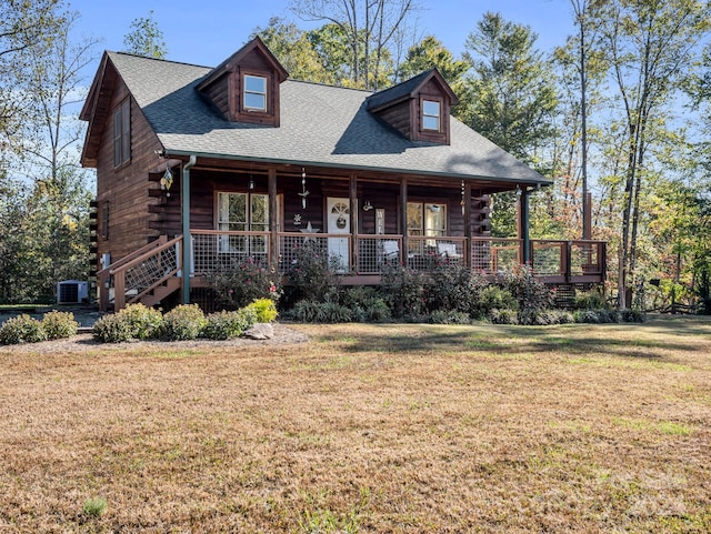 log home with covered porch, a front yard, and central AC unit