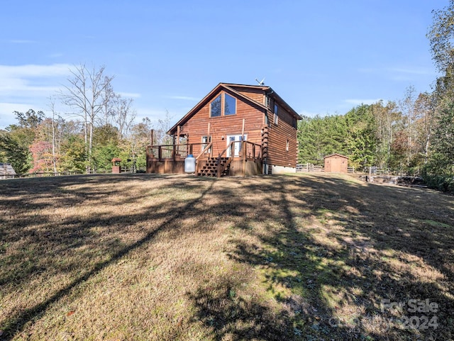 rear view of house featuring a shed and a yard