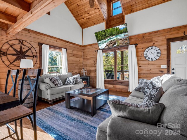 living room with wood ceiling, beam ceiling, hardwood / wood-style flooring, high vaulted ceiling, and a skylight