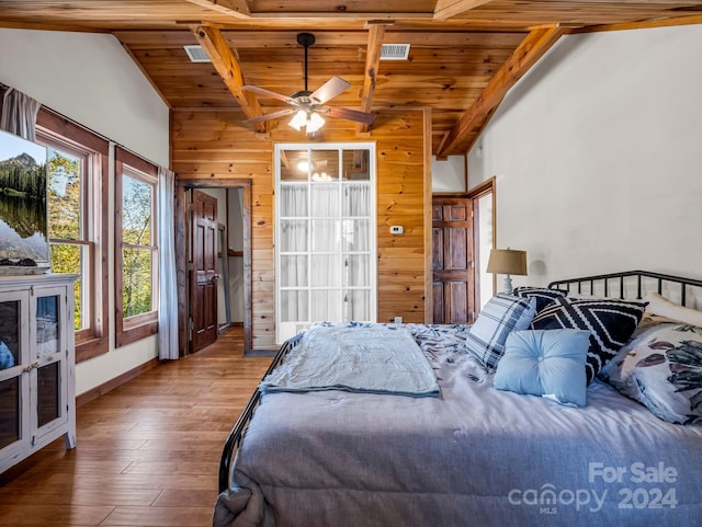 bedroom featuring wood walls, vaulted ceiling with beams, hardwood / wood-style floors, ceiling fan, and wooden ceiling