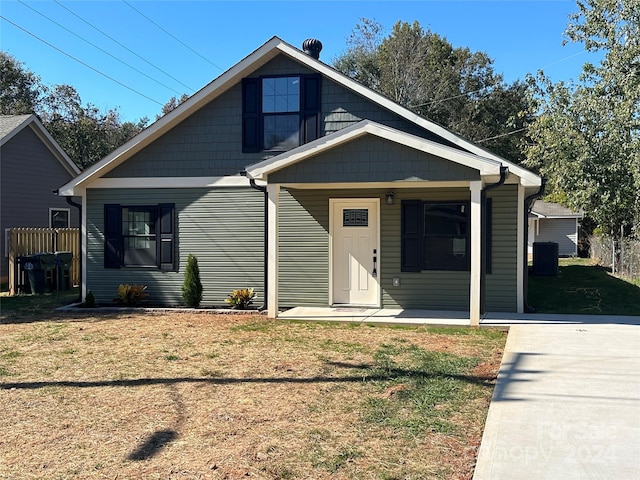 bungalow with a porch, a front yard, and central AC