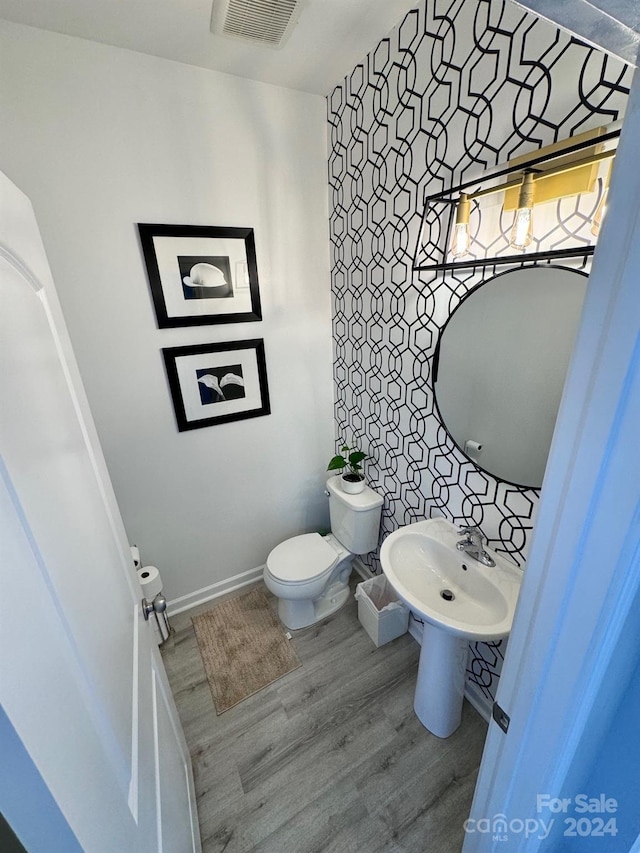 bathroom with sink, hardwood / wood-style floors, and toilet