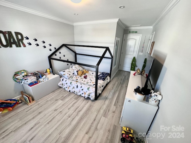 bedroom with ornamental molding and light hardwood / wood-style flooring