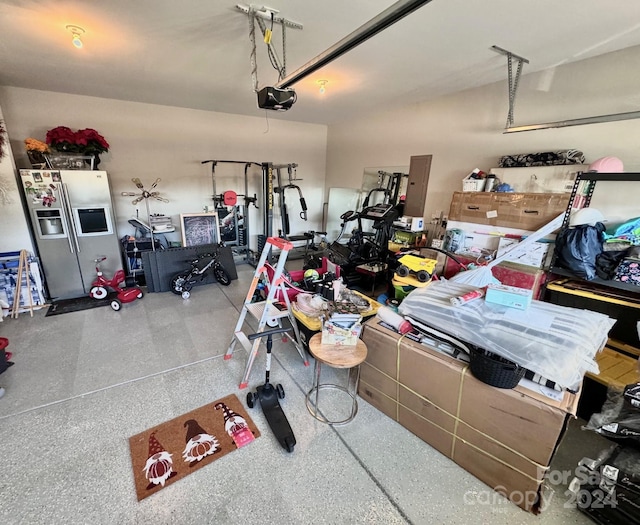 garage featuring electric panel, a garage door opener, and stainless steel fridge with ice dispenser