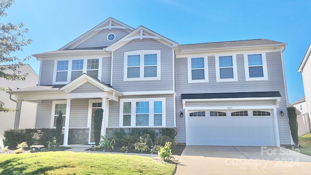 view of front of property with a front yard and a garage