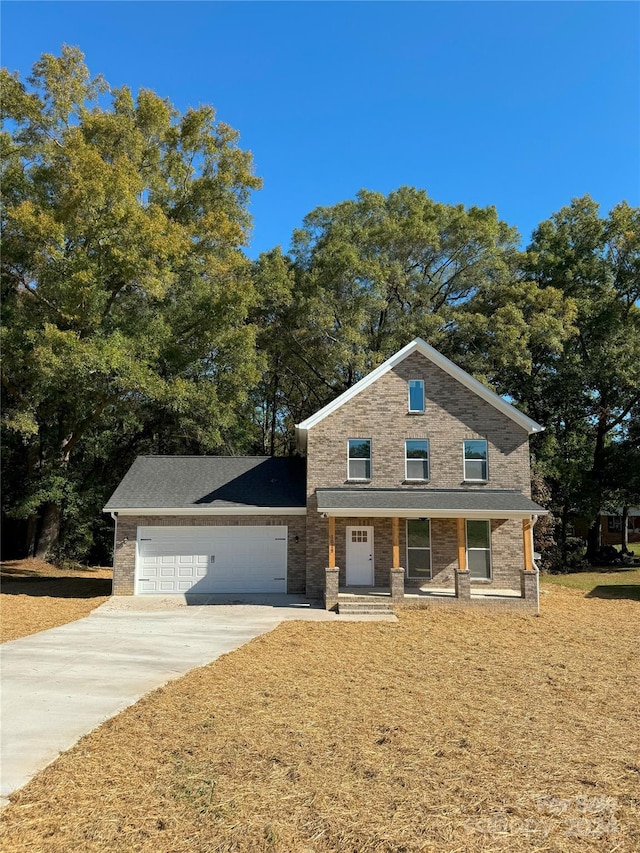 view of front of home featuring a porch, a front lawn, and a garage