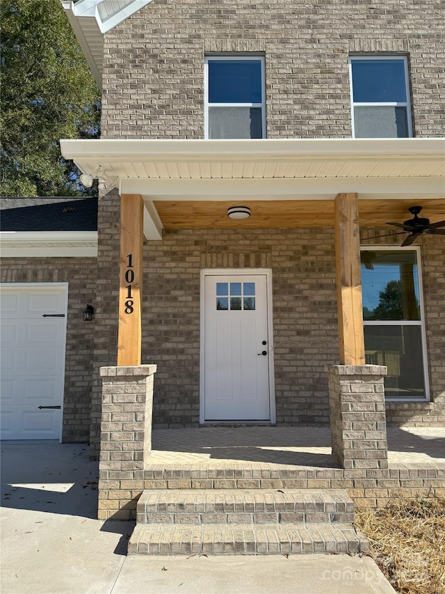 property entrance with ceiling fan, a porch, and a garage