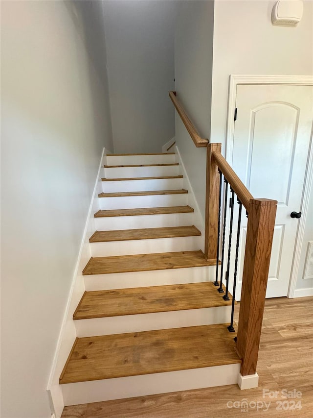 stairway with hardwood / wood-style floors