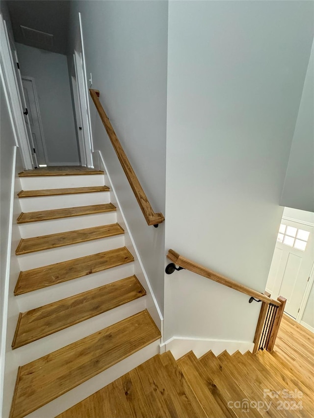 staircase with hardwood / wood-style floors