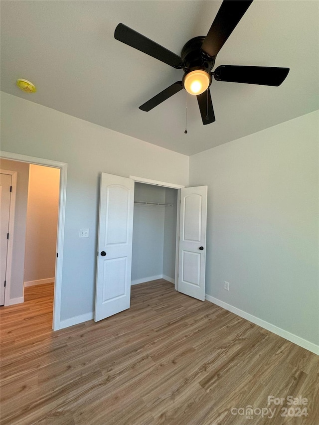 unfurnished bedroom featuring a closet, light wood-type flooring, and ceiling fan