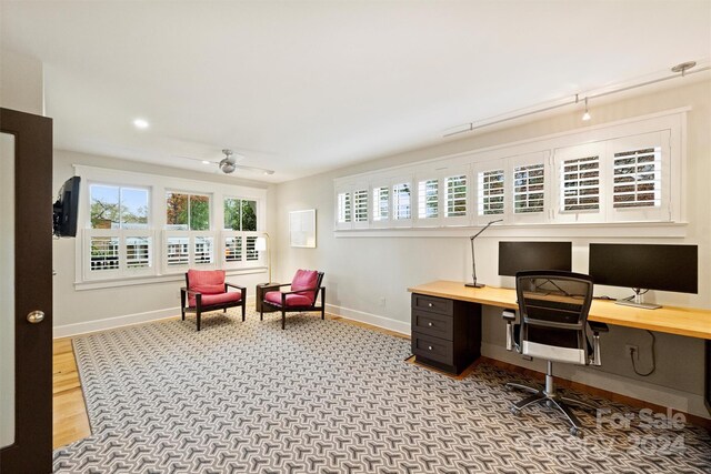 office area with built in desk, ceiling fan, and light hardwood / wood-style flooring