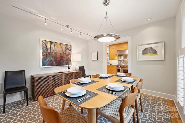 dining area featuring track lighting and wood-type flooring