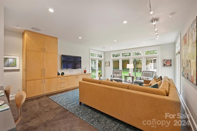 living room featuring track lighting and dark tile patterned flooring