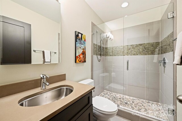 bathroom featuring walk in shower, vanity, and toilet