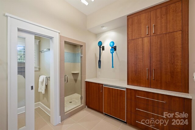 bathroom with tile patterned floors and a shower with door