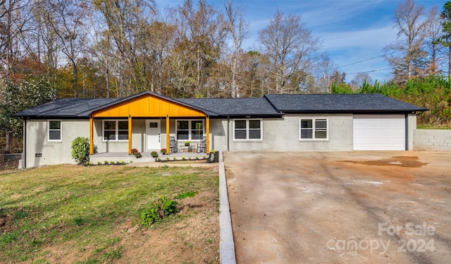 ranch-style home with a front yard, a porch, and a garage