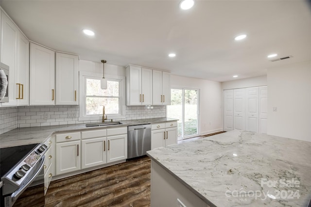 kitchen featuring hanging light fixtures, sink, dark hardwood / wood-style floors, appliances with stainless steel finishes, and white cabinetry