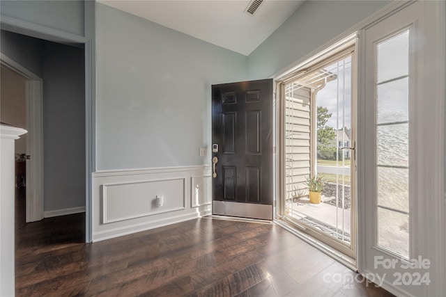 foyer entrance with dark wood-type flooring and vaulted ceiling