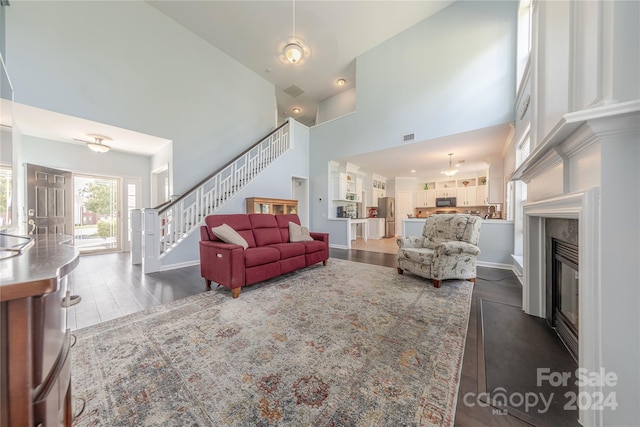 living room with dark hardwood / wood-style floors and a high ceiling