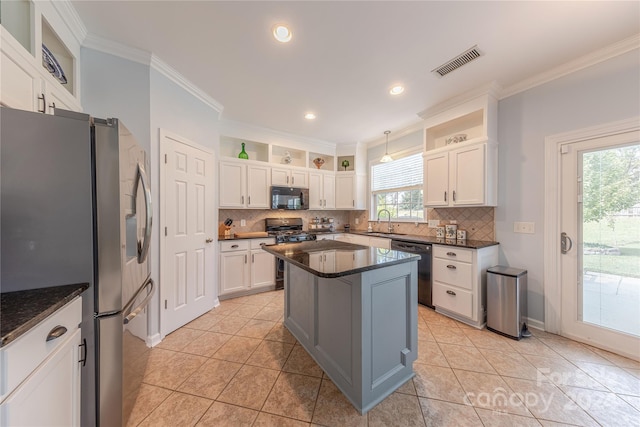 kitchen with white cabinets, backsplash, ornamental molding, black appliances, and a center island