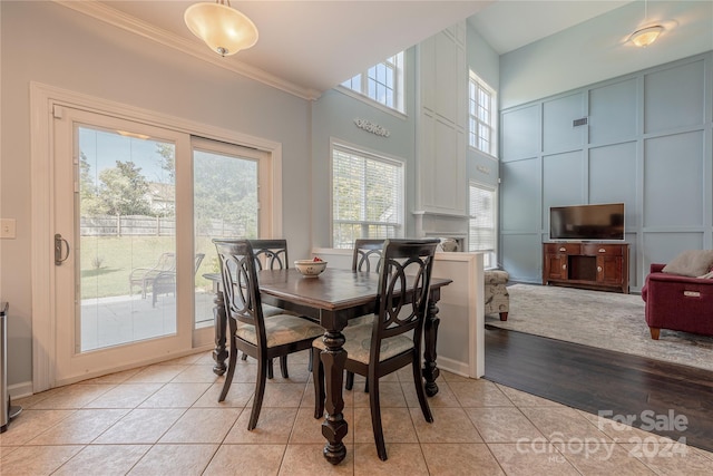 dining area featuring light hardwood / wood-style floors, ornamental molding, and plenty of natural light