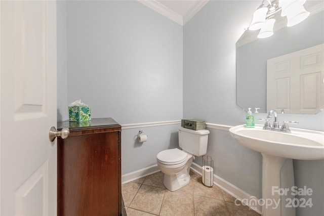 bathroom featuring toilet, tile patterned floors, ornamental molding, and sink