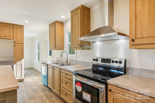 kitchen with wall chimney exhaust hood, stainless steel appliances, crown molding, sink, and light hardwood / wood-style flooring