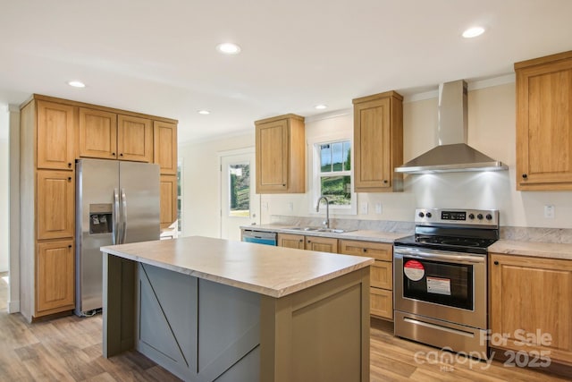 kitchen featuring light wood-type flooring, wall chimney exhaust hood, stainless steel appliances, sink, and a kitchen island