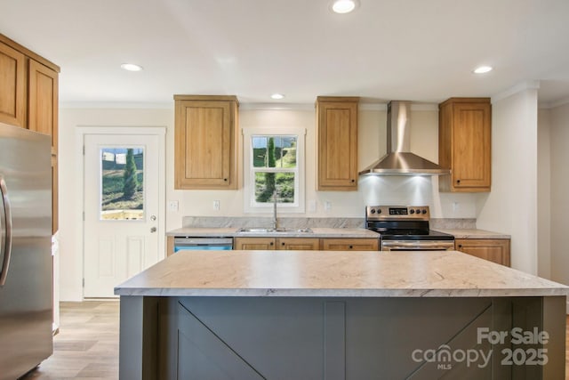 kitchen with a center island, wall chimney range hood, sink, light hardwood / wood-style flooring, and stainless steel appliances