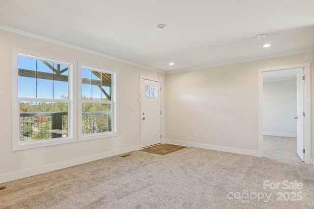 foyer featuring crown molding and light carpet