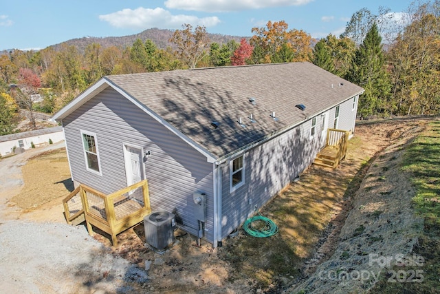 rear view of property with central AC and a mountain view