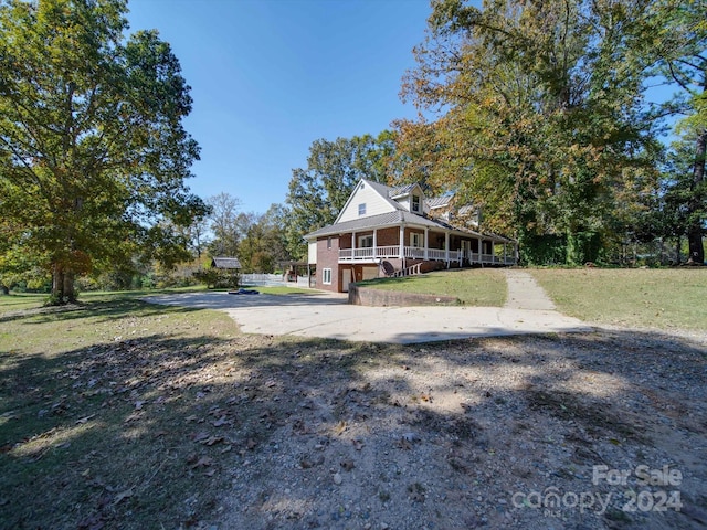 view of front of house featuring a porch, a front lawn, and a garage