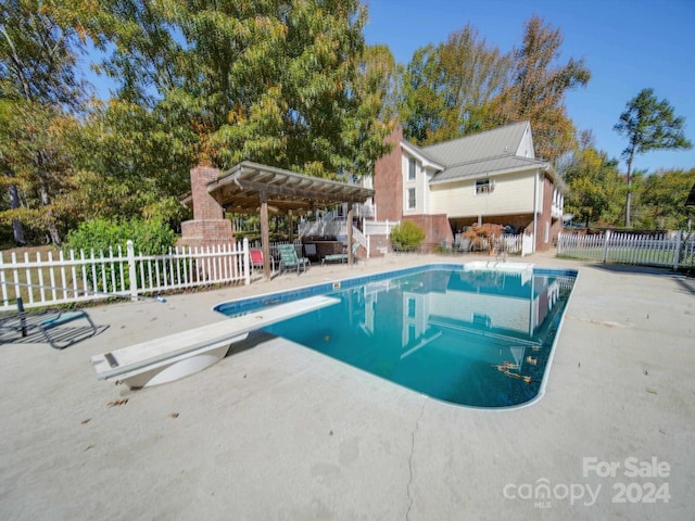 view of pool featuring a pergola, a patio, and a diving board