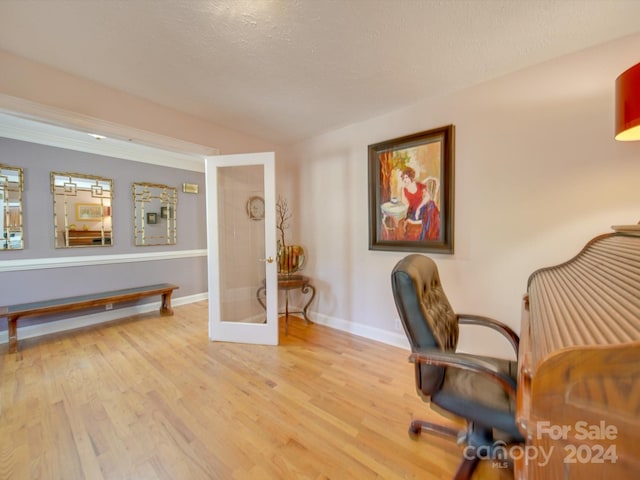 home office featuring french doors, a textured ceiling, and light wood-type flooring